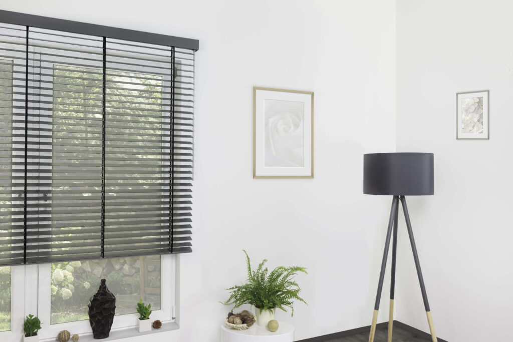 Modernes Zimmer mit einem Fenster, an den eine Jalousie vor montiert wurde.