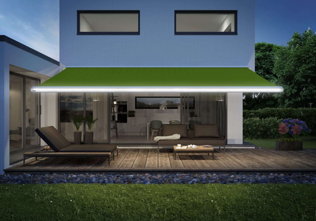 Vorderansicht, einer Terrasse eines Einfamilienhauses. Die ausgefahrene Markise hat eine LED Beleuchtung im Ausfallprofil.