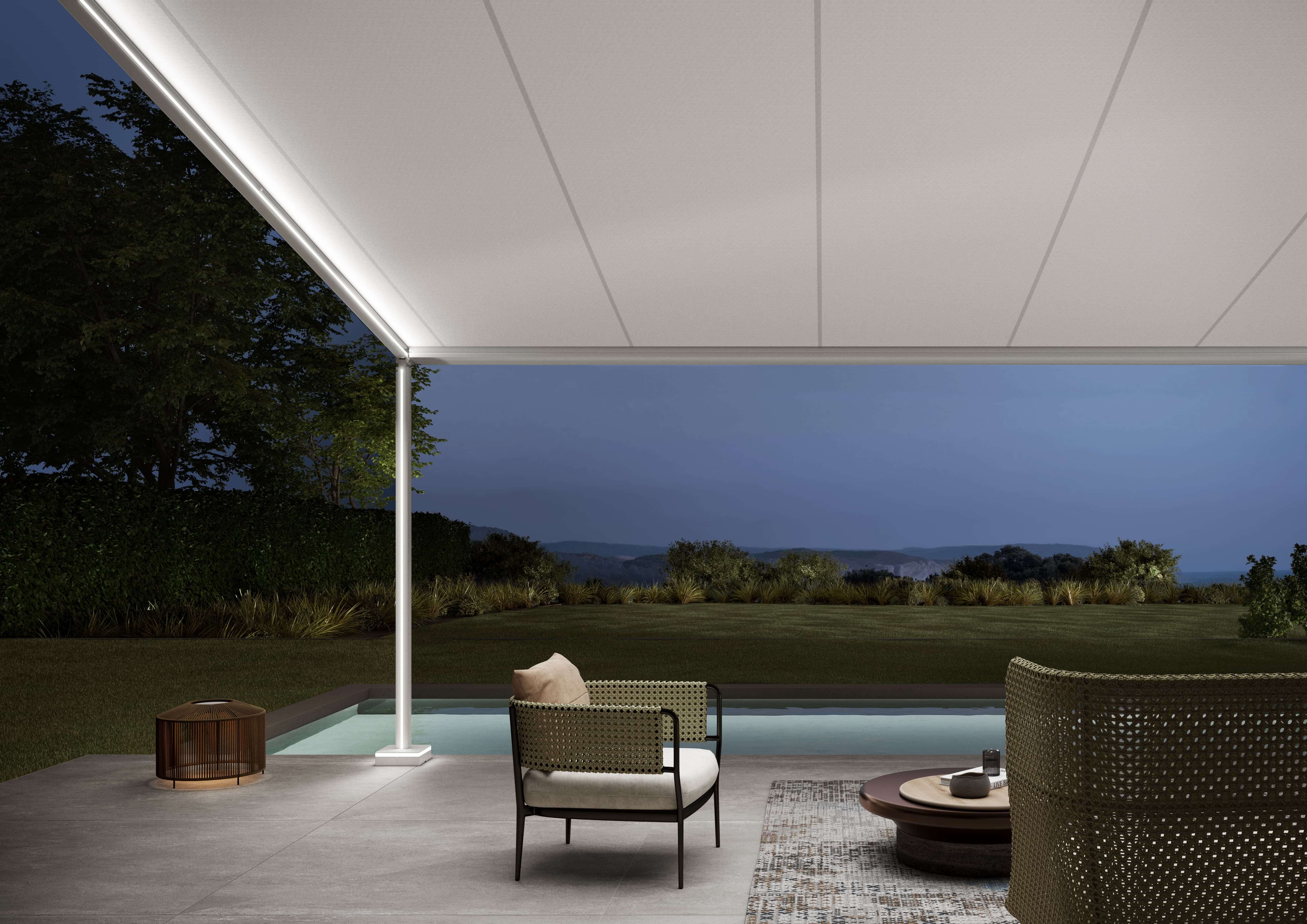 Eine Terrasse am Abend mit einer ausgefahrenen Pergola Markise. Diese Pergola Markise hat LED Beleuchtung in der Säule und in der seitlichem Führungsschiene.