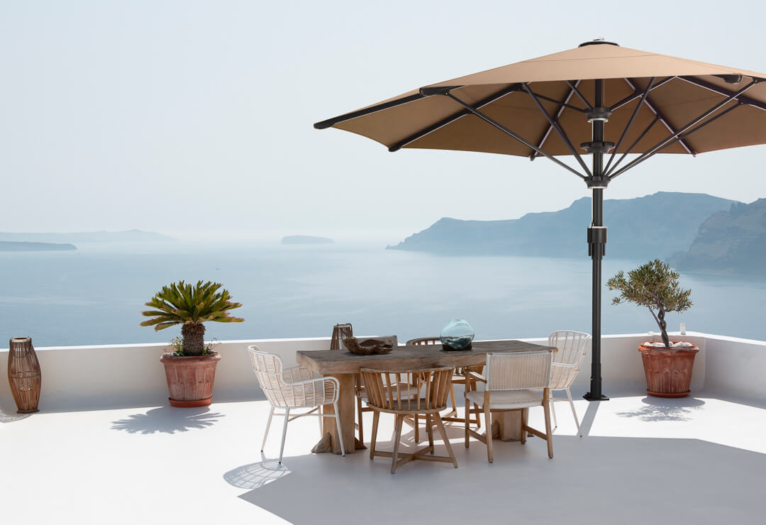 Sonnenterrasse am Meer mit Gartenmöbeln und einem Sonnenschirm