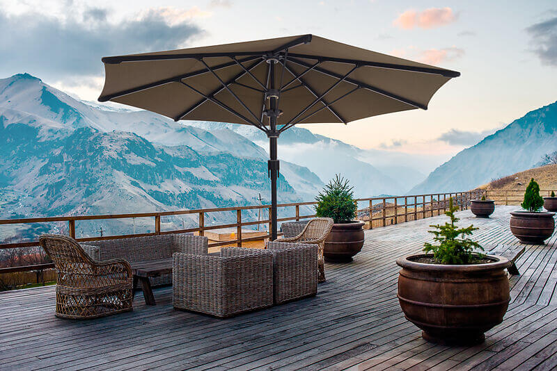 Terrasse in den Bergen mit einer Lounge und einem runden Sonnenschirm