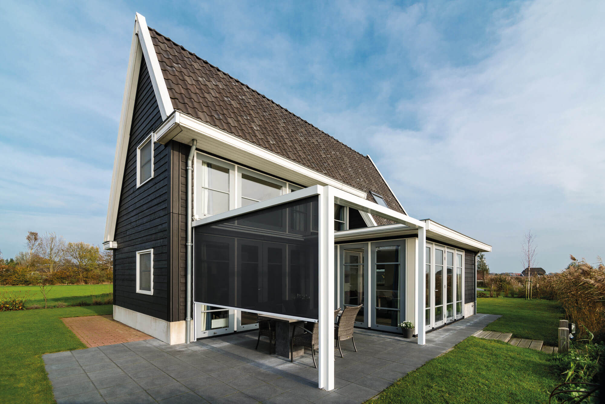 Einfamilienhaus mit einem Terrassendach, an dem seitlich ein Screen zum Sichtschutz montiert ist