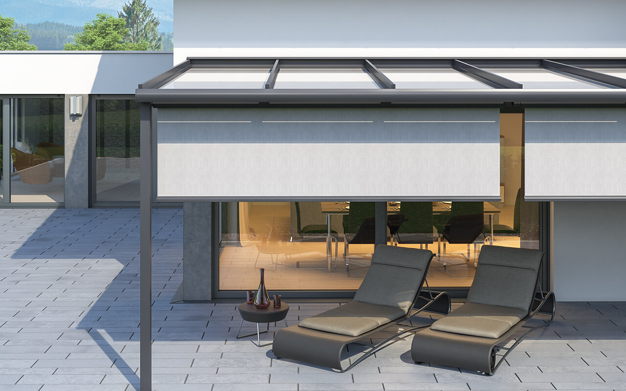 Terrasse an einem Einfamilienhaus mit einem Terrassendach. Die Terrassendach Markise ist ausgefahren und der Schatten plus herunter, so dass der Schattenbereich sich dadurch erweitert.